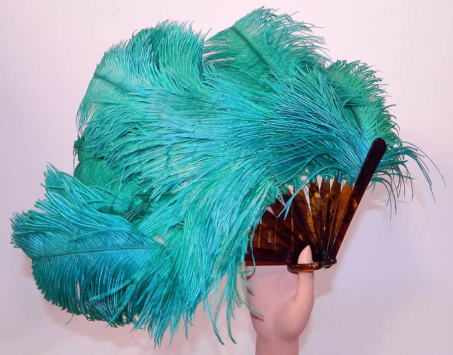 Vintage Art Deco Teal Blue Green  Ostrich Feather Folding Flapper Fan
This vintage Art Deco teal blue green ostrich feather folding flapper fan dates from the 1920s. It is made of large fluffy teal bluish green color dyed ostrich feathers plumes.