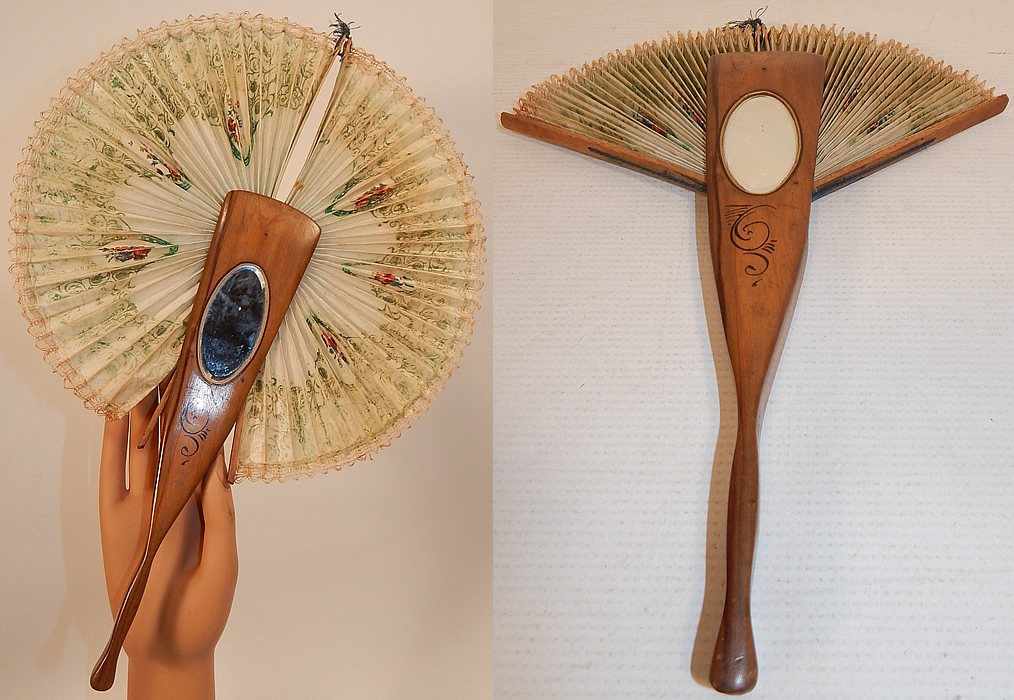 Antique Italian Ricordo Souvenir Hand Painted Wooden Cockade Flirting Mirror Fan
This unique cockade style souvenir fan opens into a complete circle around the pivot when the top string is pulled. The fan measures 10 inches long and 30 inches in circumference. 