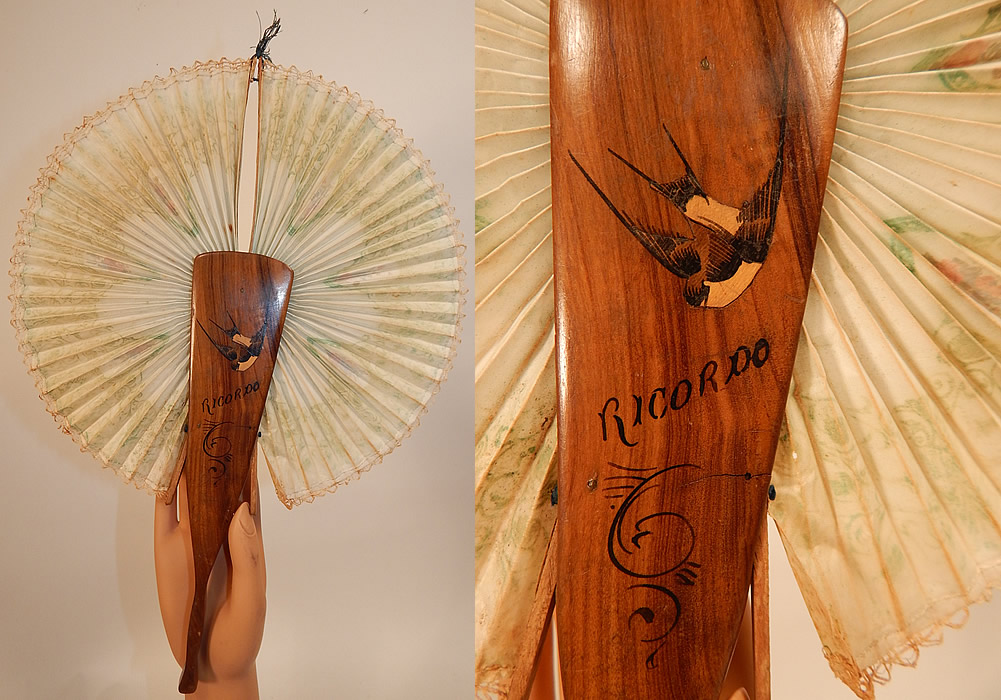 Antique Italian Ricordo Souvenir Hand Painted Wooden Cockade Flirting Mirror Fan
This antique Victorian era Italian ricordo souvenir hand painted wooden cockade flirting mirror fan dates from 1900. It is made of wood with a hand painted inlaid bird, "Ricordo" the Italian word for remembrance, souvenir on one side and a oval shape mirror for flirting on the other side. There is pleated paper with a green and red floral print rococo designs and white lace trim edging.