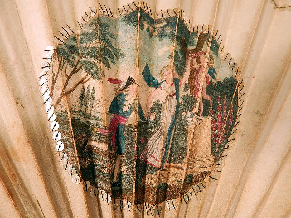 Antique 18th Century Hand Painted Paper Sequin Pierced Carved Folding Fan & Box
There is a beautiful vignette of a romantic couple in love with cupid, white doves and garland of flowers on a pedestal. 