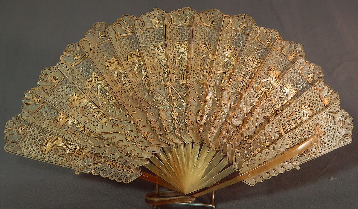 Antique Indonesia Java Wayang Shadow Puppet Gold Painted Pierced Folding Fan
It is made of a translucent animal skin vellum, possibly water buffalo hide, which has been ornately hand pierced, painted gilded in gold with cut out figures of wayang kulit shadow puppets, scalloped trim edging and carved water buffalo horn sticks, guards with bottom ring holding it together. 