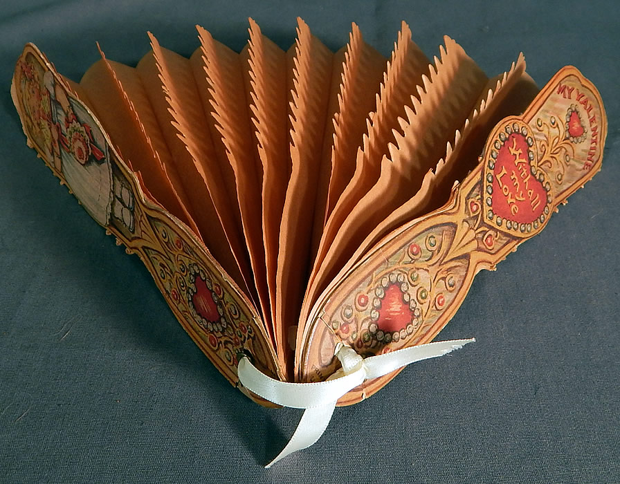 Vintage Beistle Die Cut Valentine Card Fold Out Pleated Tissue Paper Folding Fan
The little girl resembles the Dolly Dingle illustrations done by Grace Drayton and is the same type of child illustration which later became the Campbell Soup Kids. 