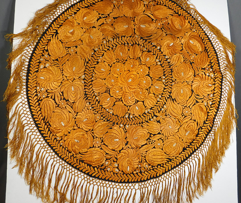 Antique Matyo Hungarian Folk Embroidery Yellow Floral Fringe Round Tablecloth
There is a floral garland laurel leaf wreath ring design densely embroidered onto the fabric in a circular pattern and hand knotted macrame yellow silk fringe trim edging.