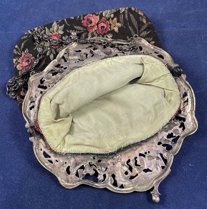 Antique Dutch Figural Fishing Boat Silver Plate Repousse Cutwork Frame Tapestry Purse
There is a kiss ball clasp closure on the top and heavy silver beaded chain link strap for carrying. This delightful Dutch inspired purse has a black, green and pink woven floral roses pattern jacquard loom weave tapestry fabric and is fully lined in a green silk fabric inside.